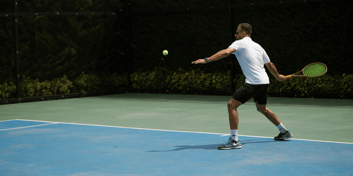 Tennis player preparing to hit a ball on a court with a net backdrop