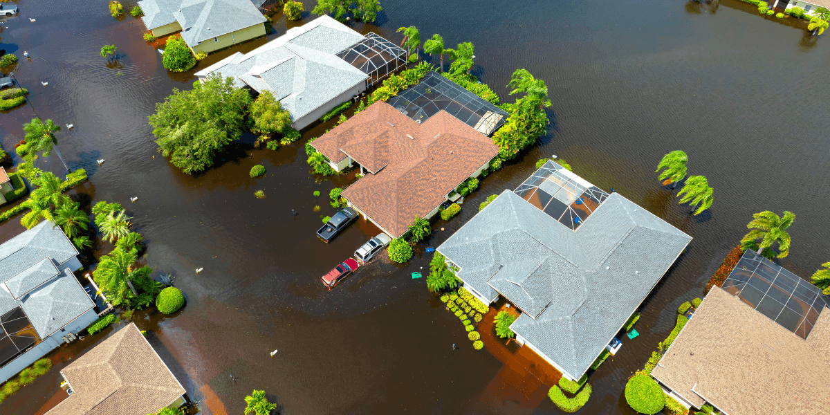Aerial view of flooded suburban homes with water covering driveways and yards