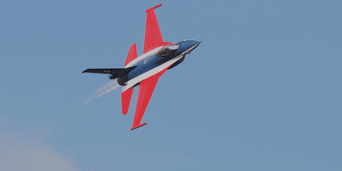 A jet aircraft performing a maneuver against a clear blue sky