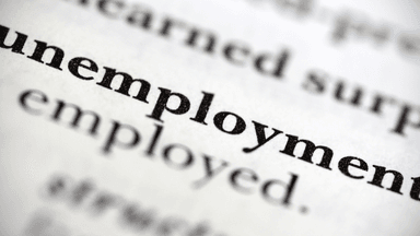 Close-up of the word "unemployment" highlighted in dictionary text