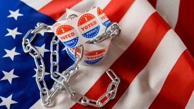 Voting stickers are wrapped in a chain on an American flag background