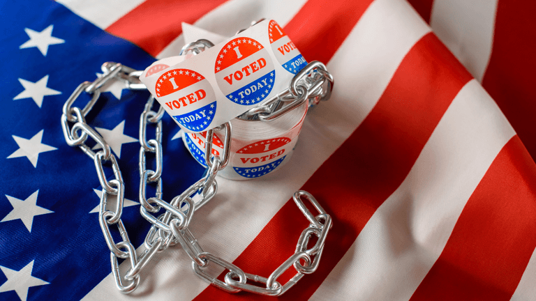 Voting stickers are wrapped in a chain on an American flag background