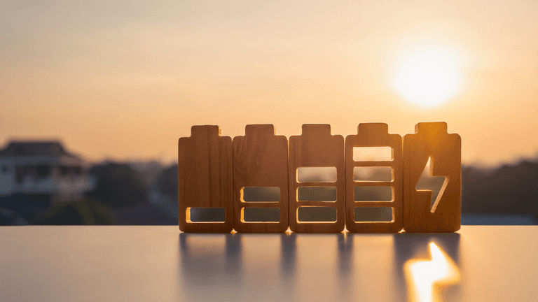 Wooden battery icons in various charge levels against a sunset background