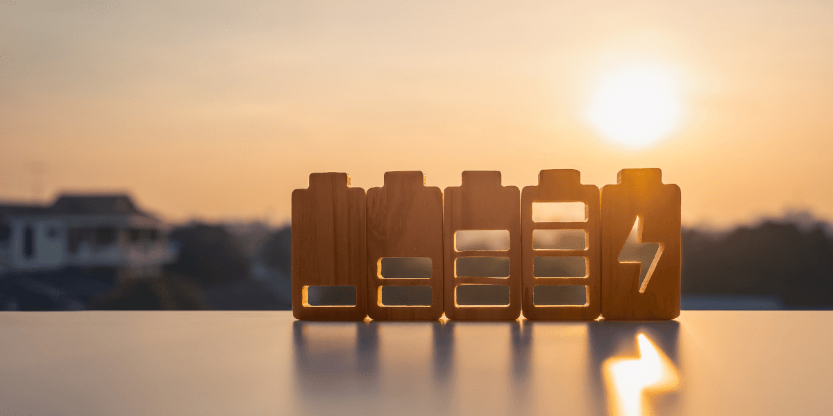 Wooden battery icons in various charge levels against a sunset background